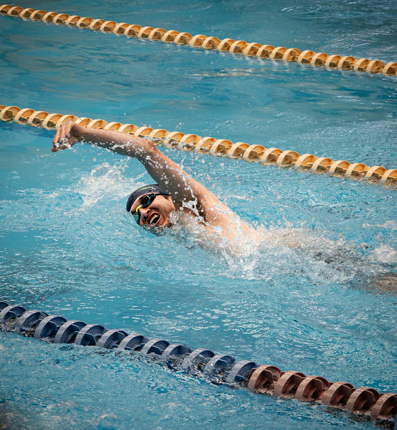 Close-up of black performance swim fabric with water droplets and splash